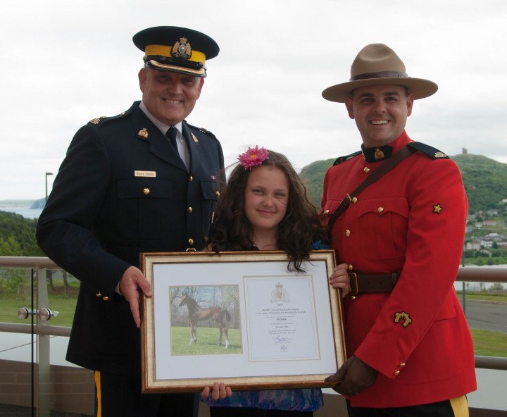 Vanessa Earle accepting her award from Insp. Bruce Singer and Cst. Brad Squires