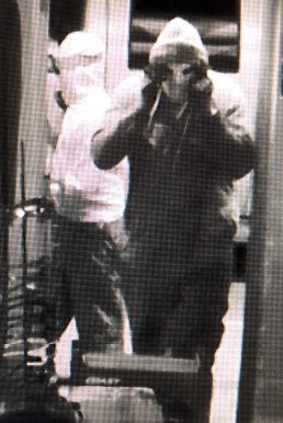Suspect portant un chandail à capuchon de couleur foncée et un masque