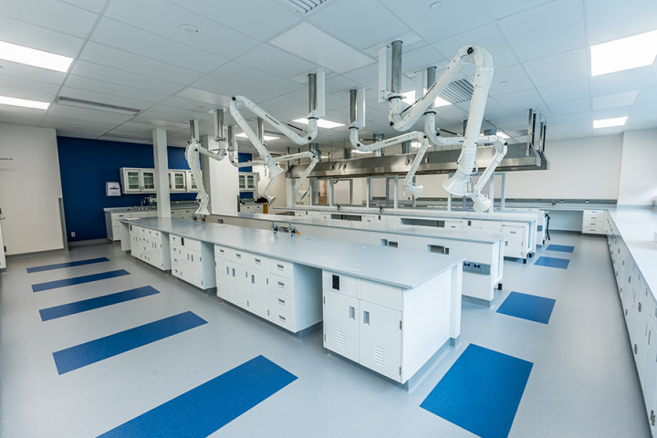 Salle de laboratoire avec longues tables blanches et bras de ventilation spécialisés suspendus au plafond. (Toutes les photos fournies par Shane O'Connor)