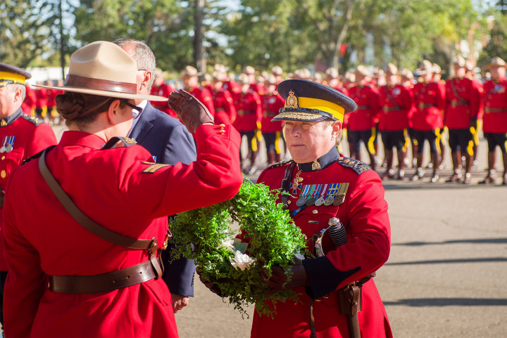 RCMP Commissioner Brenda Lucki receives a salute after being handed a wreath.