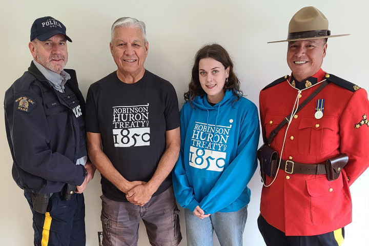 Cst. Serge Montreuil (left) and Cst. Jeff Chartrand (right) stand with Band members Kenneth Dokis and Alicia Speck at Nipissing First Nation