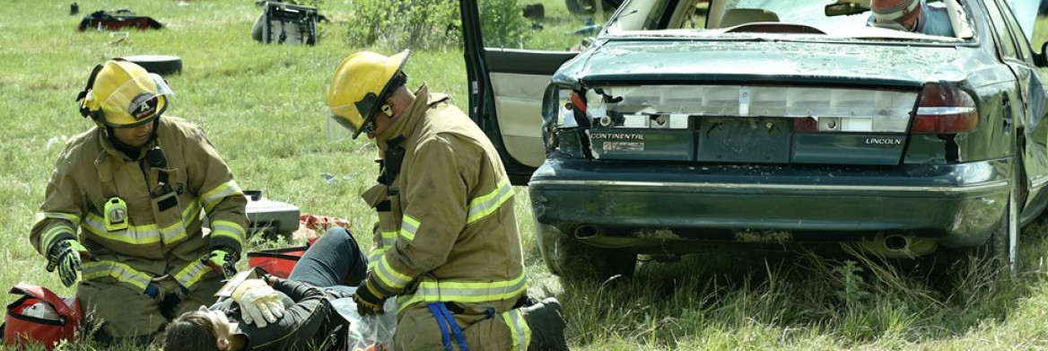 Two firefighters treat injured person near airplane crash.