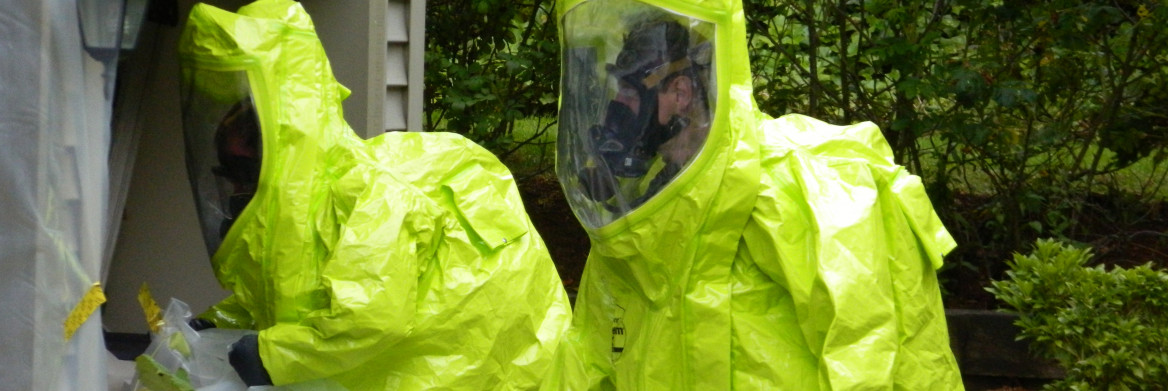 Two men in large yellow suits that cover their body and face.