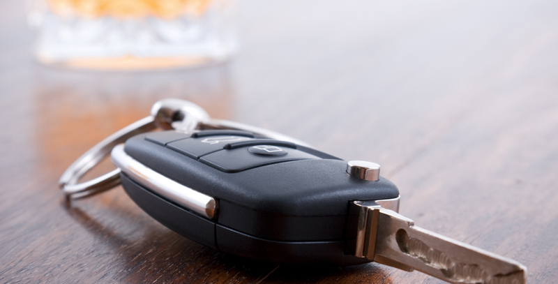 A car key and drink are on a table.