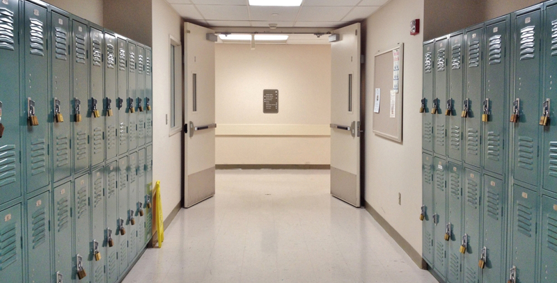 Un couloir vide avec des casiers verts sur chaque côté.