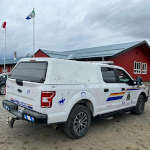 Colourfully marked RCMP police vehicle parked in front of school after being drawn on by children during the Colour the Cruiser event.