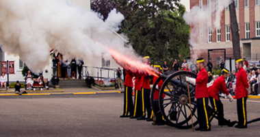 Members in red uniforms setting off cannon.