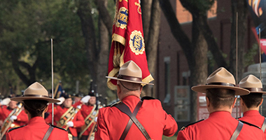 Members is red uniforms carrying the Guidon