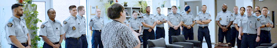 A librarian speaks to a troop of cadets in the library.
