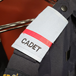 A close up of a light blue epaulette with a red stripe.