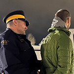 Two cadets arrest a scenario actor at night.