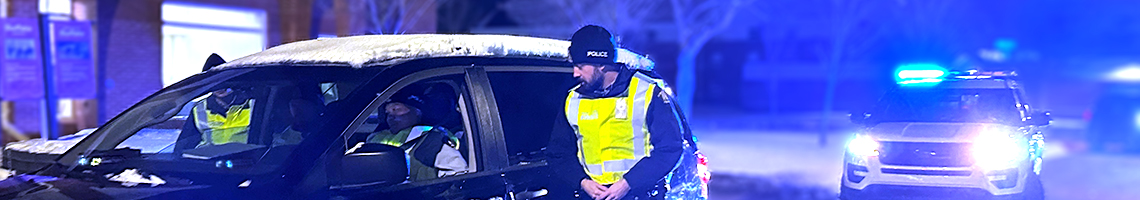  A cadet speaks to the driver of a vehicle at night.