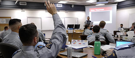 A cadet raises their hand to ask a question in class.  