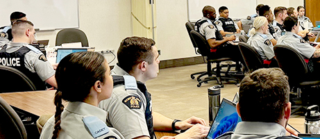 A troop takes part in a module in a classroom with laptops.