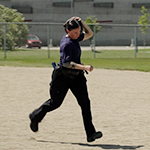 A cadet runs outside carrying a weighted object over her shoulder