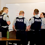 A group of cadets brainstorm ideas on a white board. 