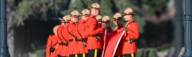 A group of cadets in red serge work together to fold the Canada flag. 