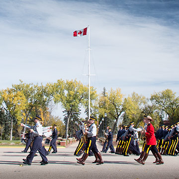 Cadets march in front of the Canadian flag