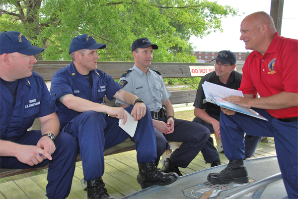 A U.S. Coast Guard instructor provides feedback following a mock vessel platform boarding.