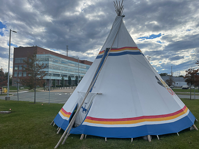An RCMP teepee is sitting in the yard of Nova Scotia RCMP headquarters; an office building is in the background.