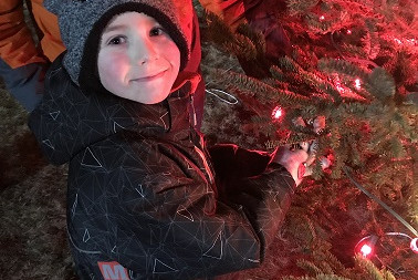 Kaleb and his dad stand next to the Wish Tree.