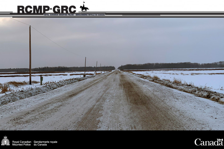 Rural Saskatchewan road in winter with open land on either side and snow in the ditches.