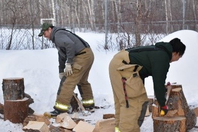 2 pompiers coupent du bois.
