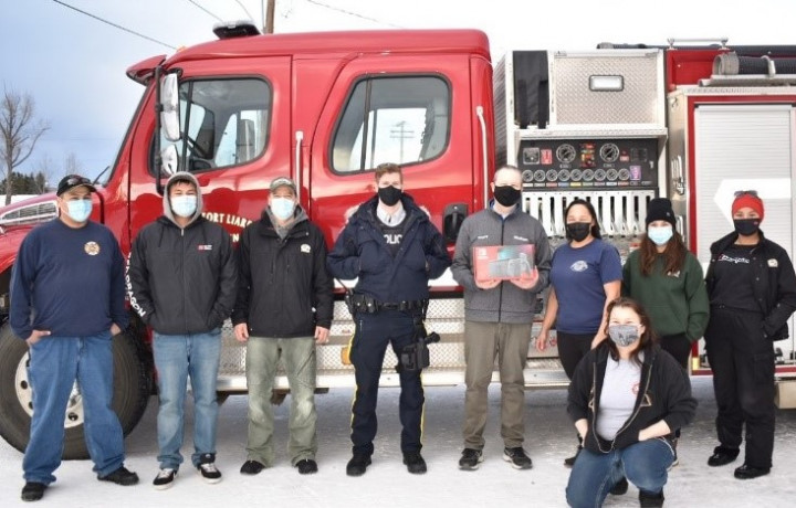 Un groupe d'adultes debout devant un camion d'incendie.