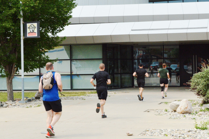 Four cadets run towards the RCMP Heritage Centre.
