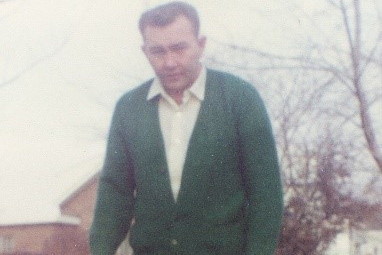 An undated photograph of Theodore Frederick Kampf wearing a light coloured collared shirt and green cardigan sweater.