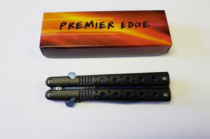 Un étui orange et brun portant la marque Premier Edge avec un couteau noir à ouverture automatique, en position fermée. Il s'agit d'une arme prohibée.