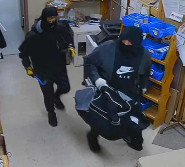 Deux personnes entrant dans le PharmaChoice à Bonne Bay lors d'un vol avec effraction. Les deux portaient un couvre-visage et des vêtements noirs. Un des suspects porte un sac de sport gris et noir.