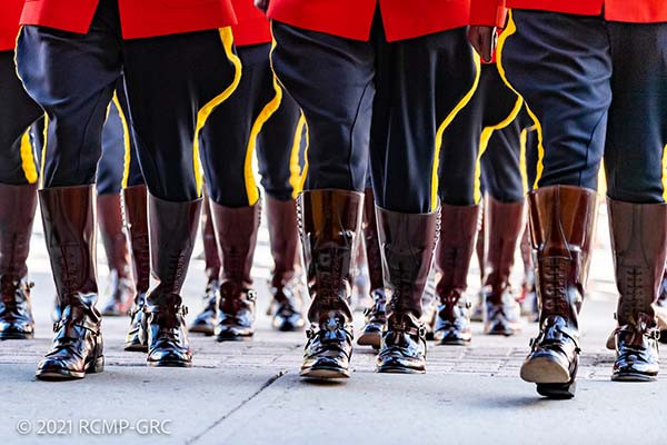 Une troupe de cadets en tunique rouge marche à l'extérieur.