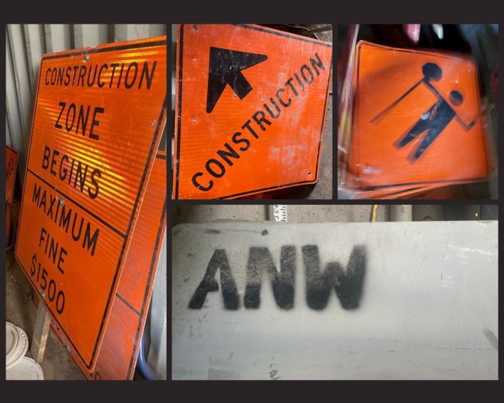 A collage of construction signs. Left: an orange sign that says Construction Zone Begins, Maximum Fine $1500. Center top: an orange sign that has an arrow pointing forward with the word Construction. Top right: an orange sign with the likeness of a flags person holding a stop sign. Bottom right: an unpainted back side of a sign with the letters A.N.W. stencilled in black paint.