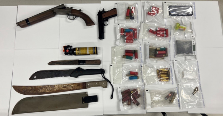Des couteaux machettes, des armes à feu et des sacs en plastique contenant des munitions et du matériel de consommation de drogue sont visibles sur un fond blanc.