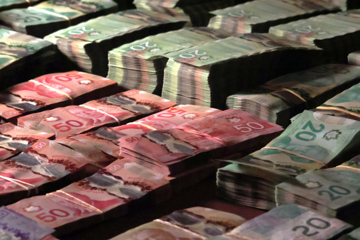  Photo of large quantities of proceeds seized in Canadian currency bound and placed on a table. 