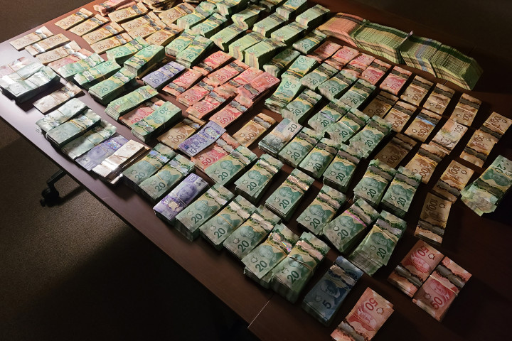  Photo of large quantities of proceeds seized in Canadian currency bound and placed on a table. 