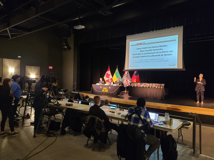Saskatchewan RCMP senior officers sit on an auditorium stage while presenting to media agencies