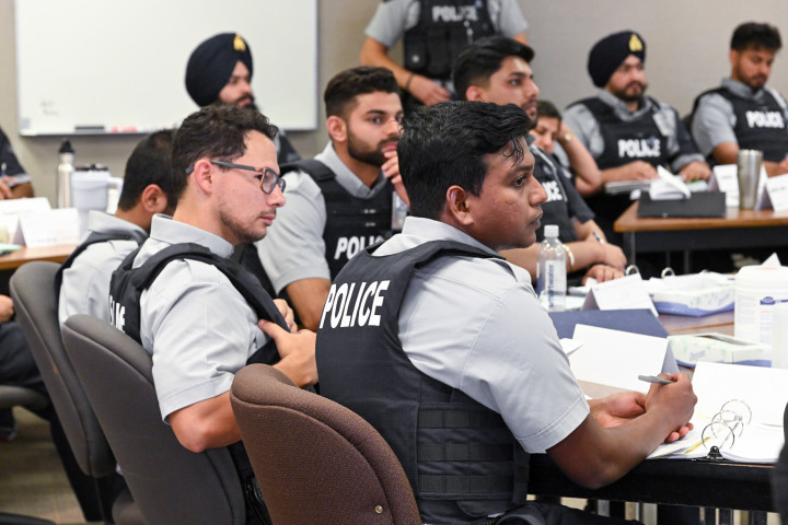Un groupe d'étudiants est assis à une table avec des classeurs ouverts.