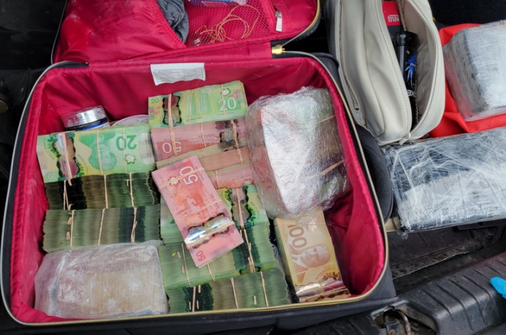 Une grande quantité d'argent à l'intérieur d'une valise trouvée dans le coffre d'un véhicule.