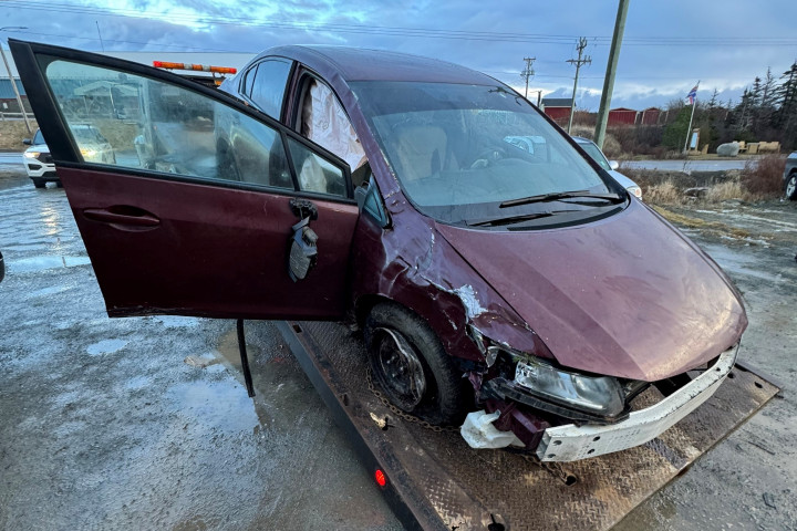 A burgundy car is shown heavily damaged. 