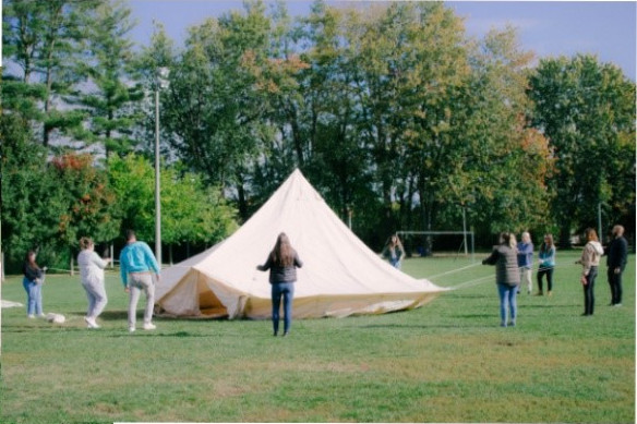 Several people erecting the Inuit tent.