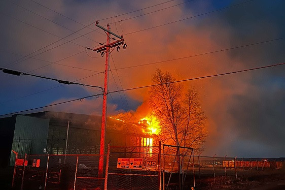 A commercial structure is on fire at night.