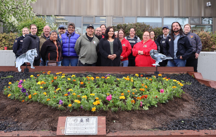 Participants standing behind the heart shaped garden