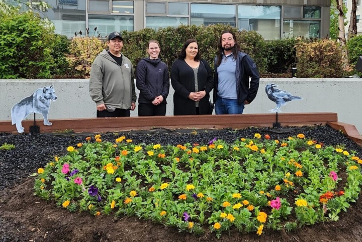 Chief Sean Smith (KDFN), Staff Sergeant Jill McLaren (RCMP), Chief Amanda Leas (TKC) and Grand Chief Peter Johnson (CYFN) standing behind the heart shaped garden