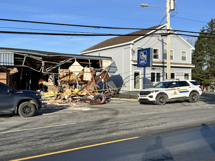 Photo of destroyed RCB building. A police car is outside.
