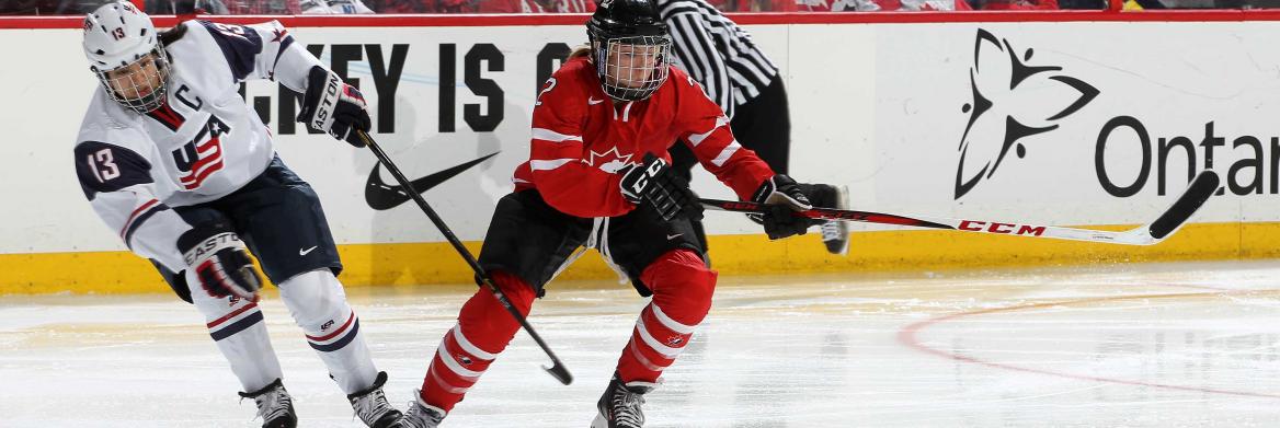 Two women playing hockey.