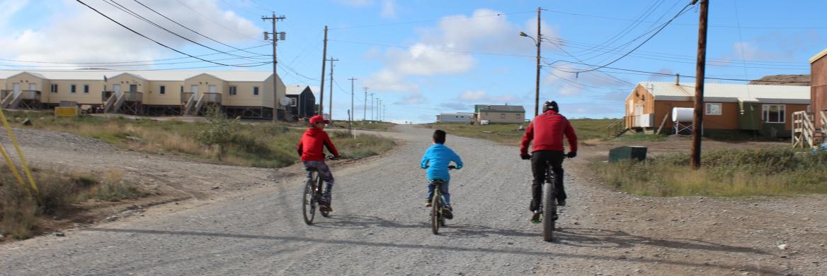 Un adulte et deux enfants se promènent en vélo.