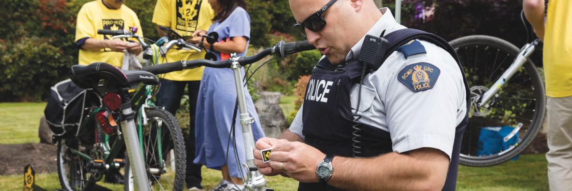 Un policier apposant un autocollant sur un vélo.