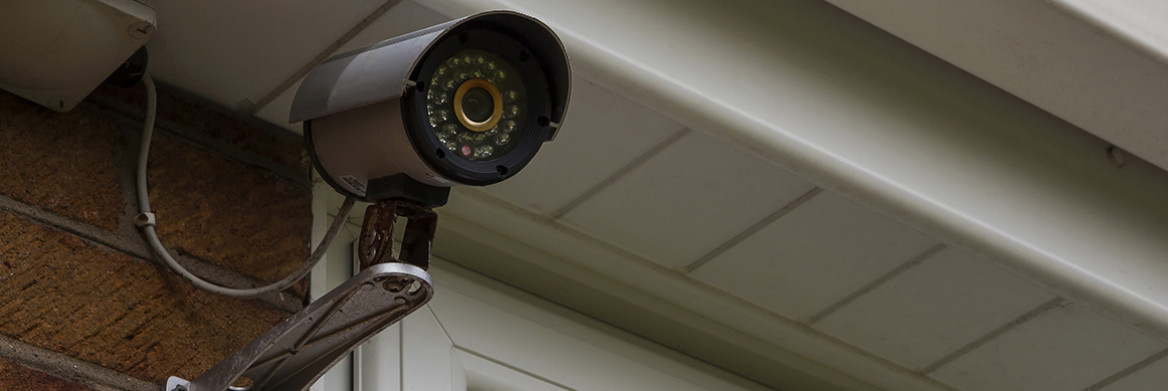 A camera installed on the corner of a house. 